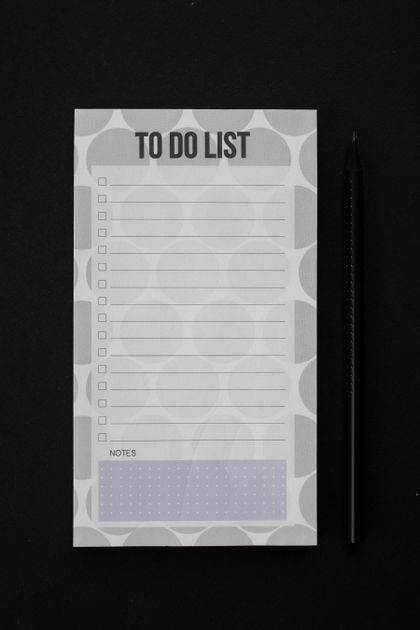 A hand marking checkboxes on a printed checklist with a pen, one small task at a time.