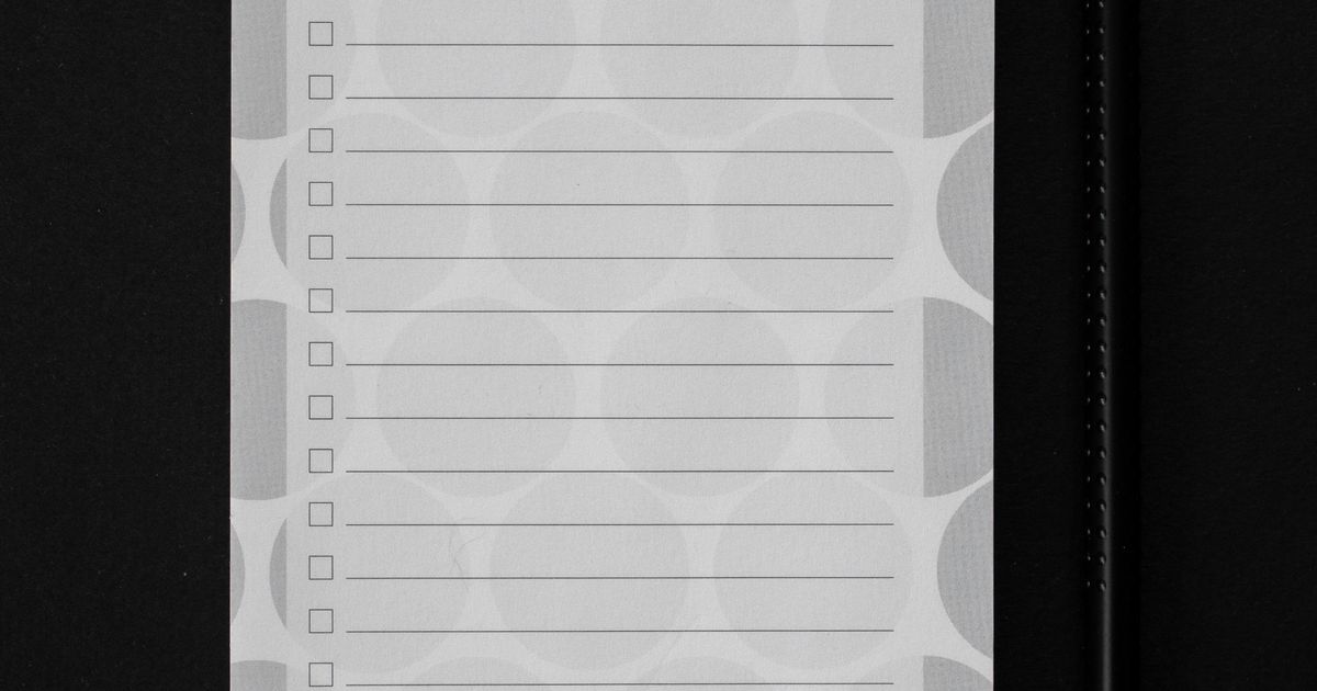 A hand marking checkboxes on a printed checklist with a pen, one small task at a time.