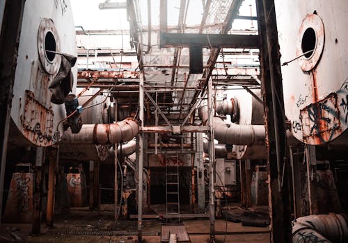 Interior of an Abandoned Factory with Rusty Pipes and Machinery 