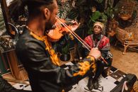 A Man Watching a Musician Playing the Violin