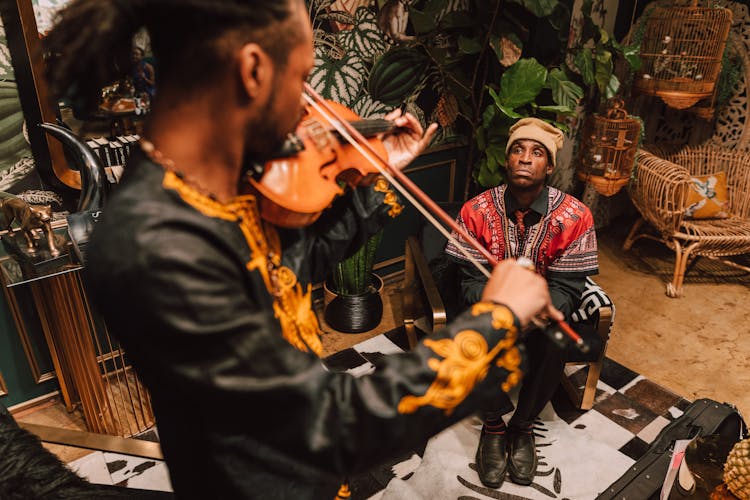 A Man Watching A Musician Playing The Violin