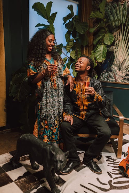 Free Man Sitting On A Chair With A Woman Standing Beside  Stock Photo