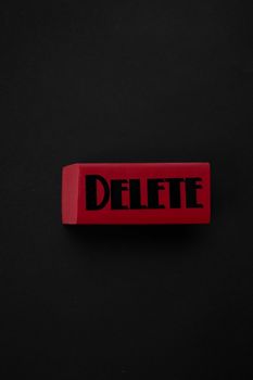 Photo by KATRIN BOLOVTSOVA Red block with 'DELETE' text on a black background, showcasing minimalism.