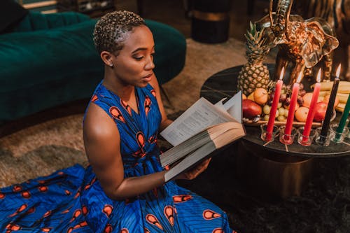 Free Woman in Blue Kaftan Dress Reading Book Stock Photo