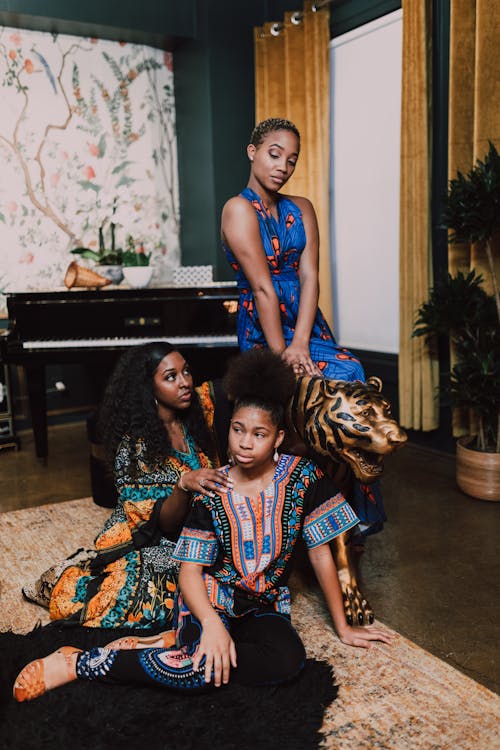 Free Women With Different Traditional Wear Posing Near A Tiger Figurine Stock Photo