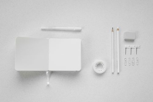 Free A minimalistic flat lay of white school supplies on a white background, featuring a notebook, pencils, and more. Stock Photo