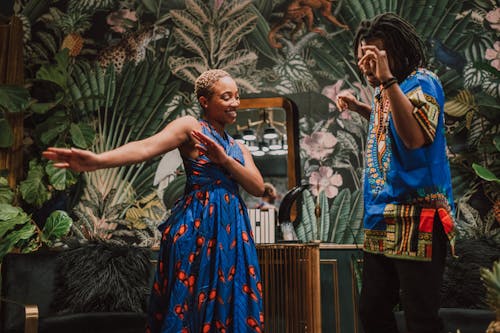 Woman in Blue and Red Dress Dancing With A Man In Blue Shirt