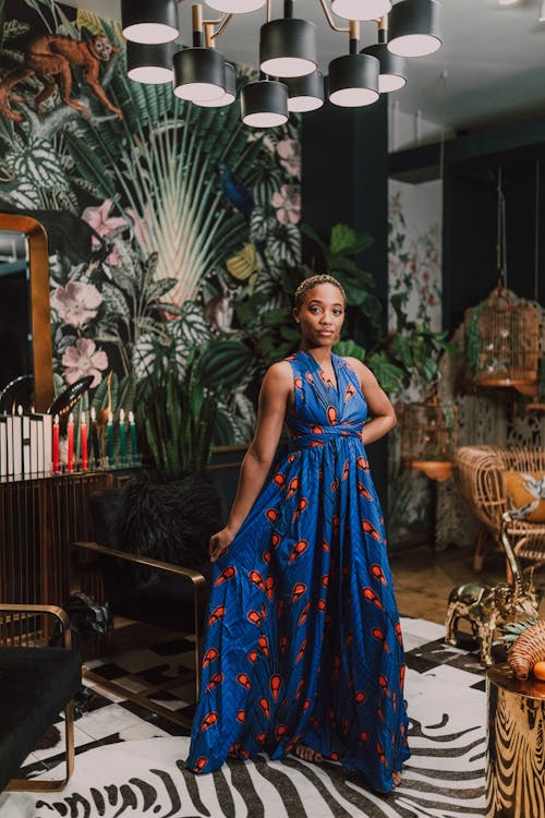 Free Woman in Blue and Orange Dress Standing Near A Chair Stock Photo