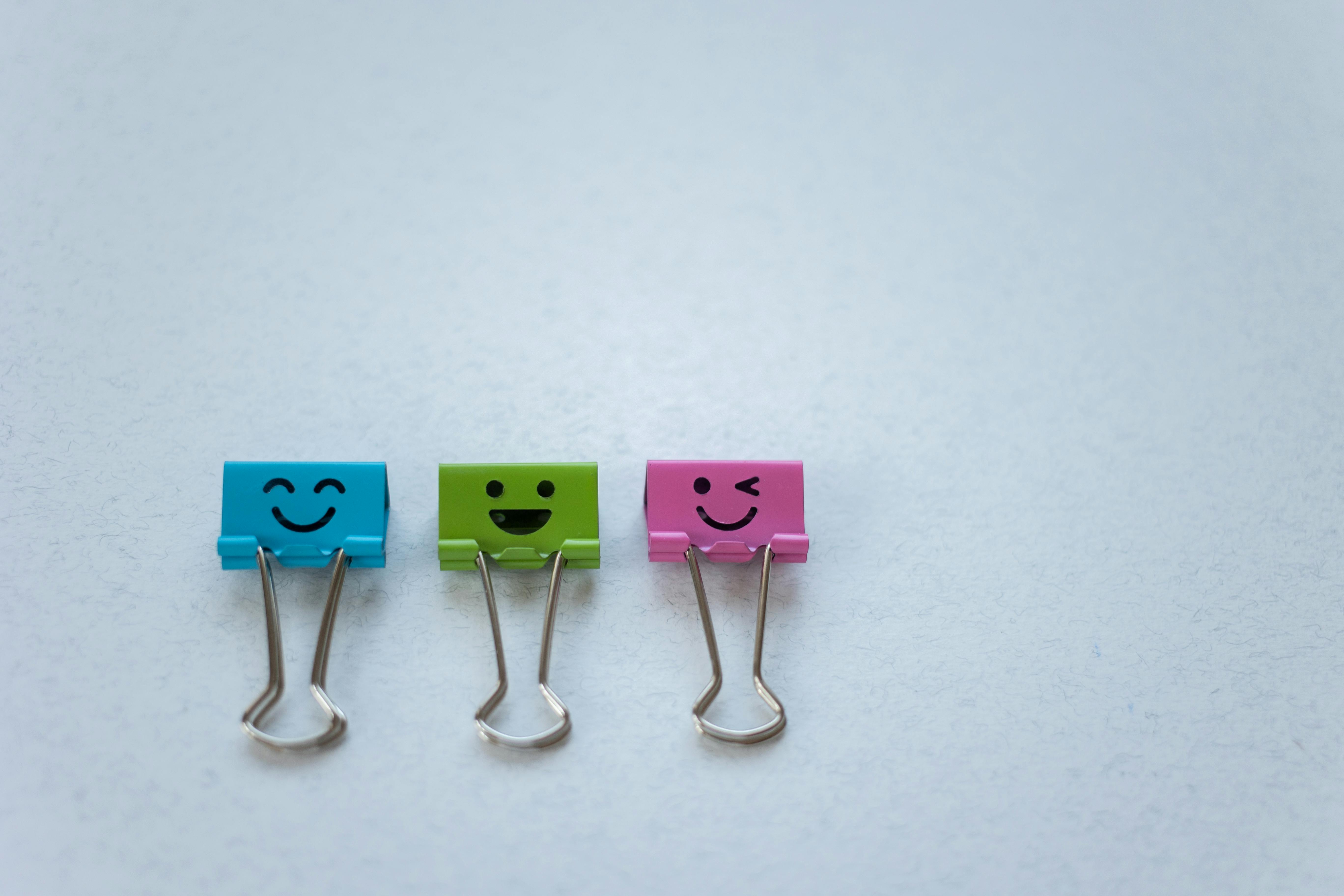 colorful binder clips on white surface