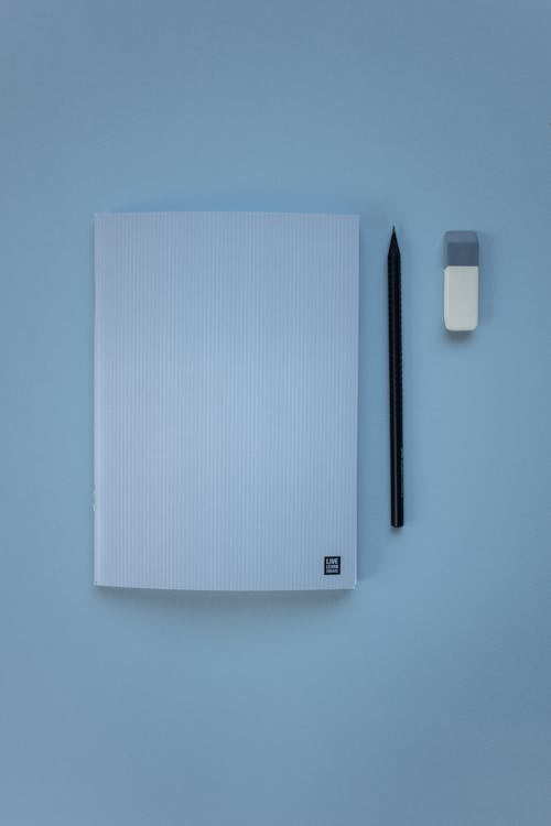 Foto profissional grátis de apagador, caderno, fundo azul bebê