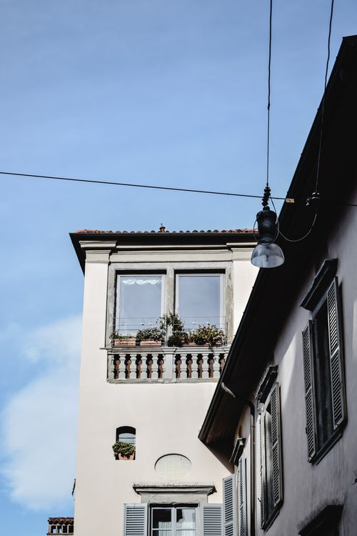 Free Historic architecture with plants and an urban light silhouette in Bergamo, Italy. Stock Photo