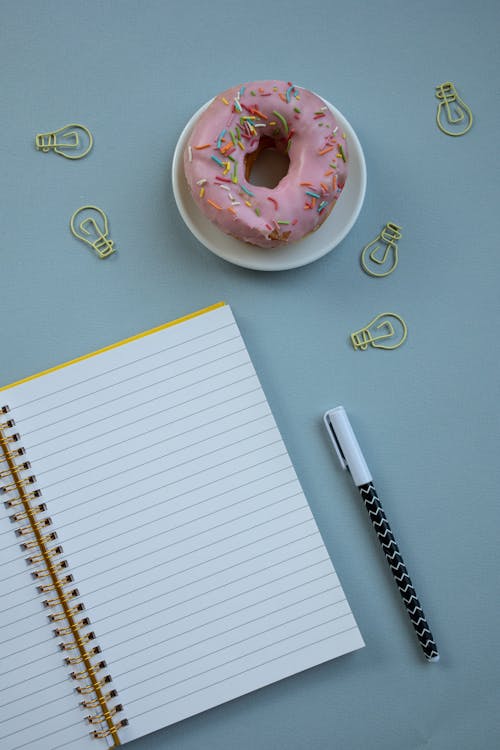 Foto profissional grátis de alimento, caderno espiral, caneta