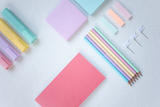 Flat lay of pastel stationery items including pencils and sticky notes, perfect for back to school themes.