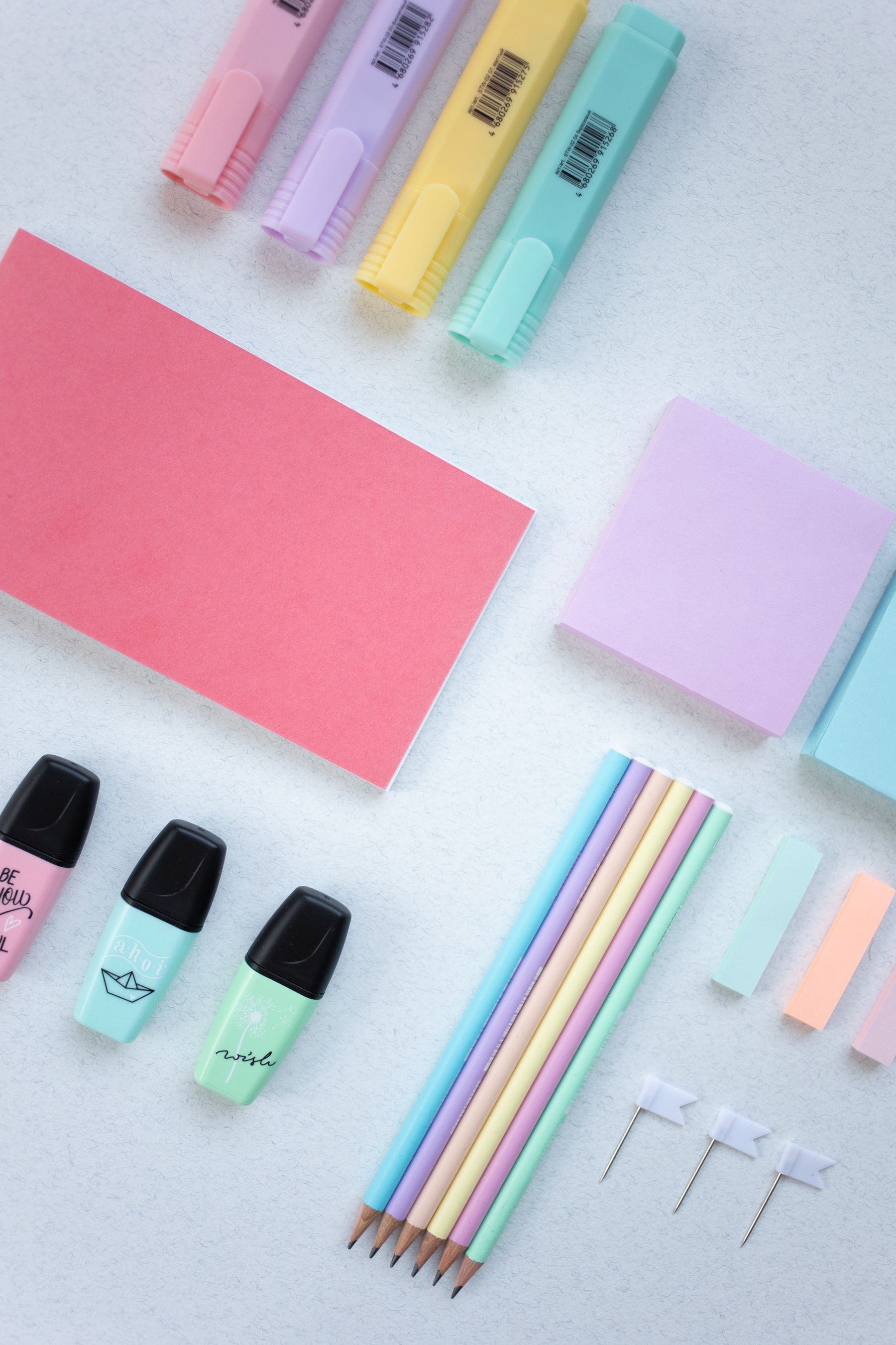Colorful stationery, notebooks, pouches, and small gifts arranged on a white surface