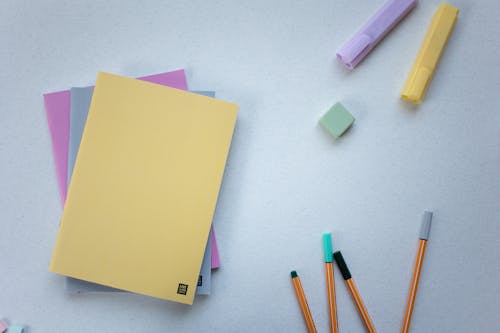 Free Colorful Notebooks Near Markers and Pencils on a Surface Stock Photo