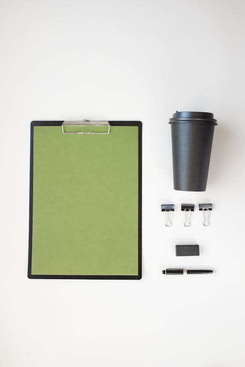 Free Coffee Cup and Stationery Items on White Surface Stock Photo