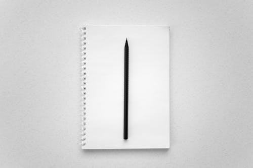 Black Pencil on White Notebook