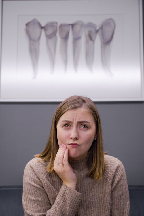 Woman in Turtle Neck Top With Hand on Her Cheek