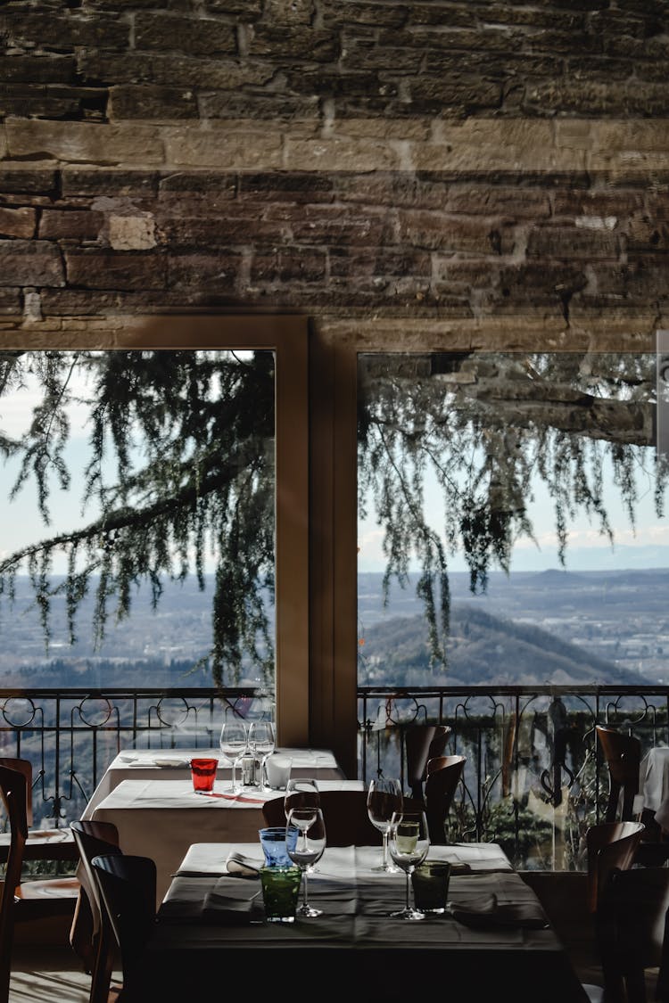 Tables And Chairs On Balcony Of A Restaurant With View Of Landscape