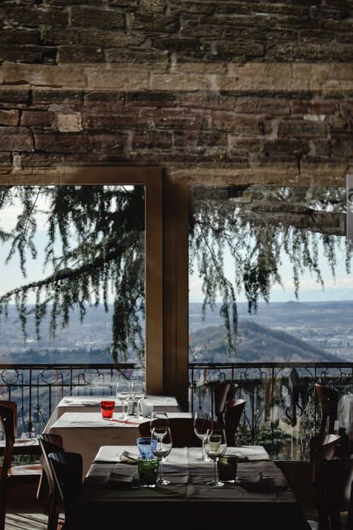 Free Elegant restaurant with a stunning view of Bergamo's hills through rustic windows. Stock Photo