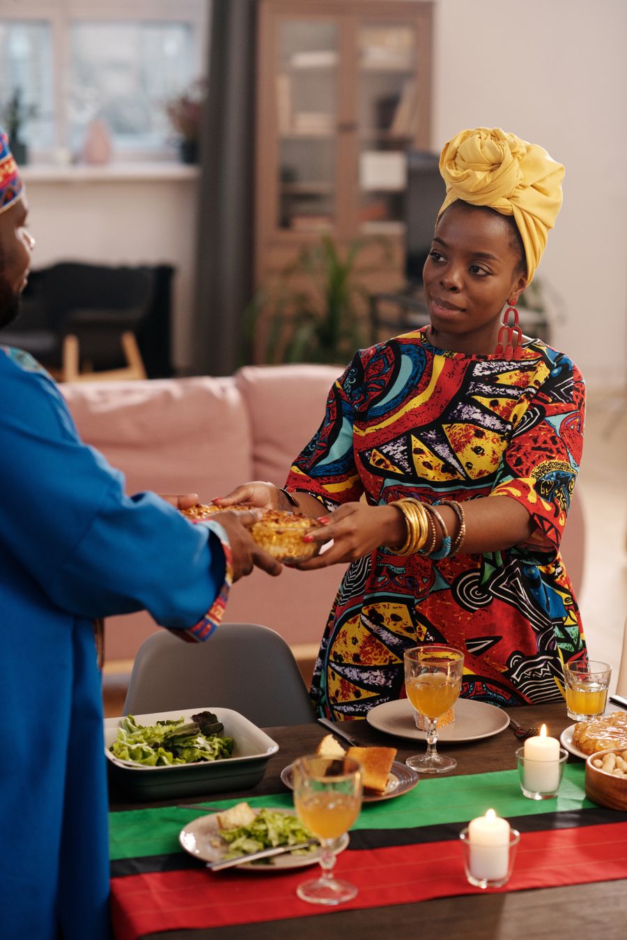 African community members in traditional attire sharing food together indoors in America