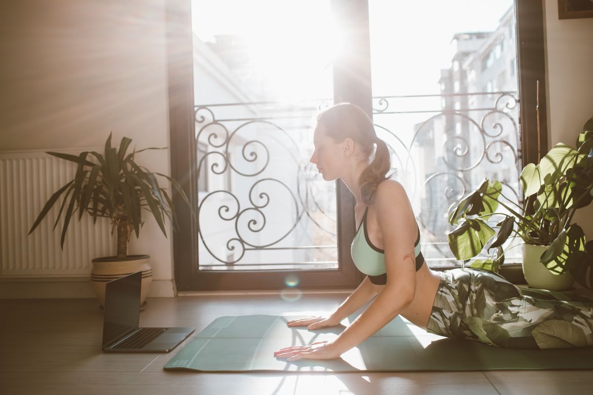 Woman in her 40s practising a gentle yoga backbend on a mat at home with sunlight streaming through the window — perimenopause exercise routine at home — Photo by Roman Odintsov via Pexels