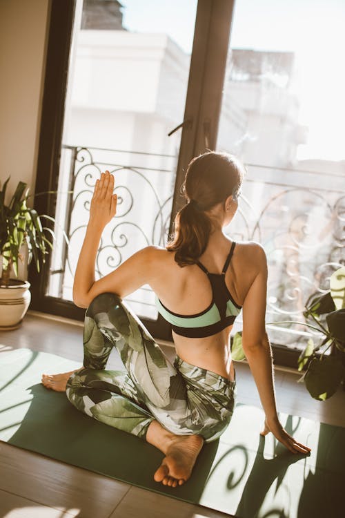 Back View of a Woman Doing Yoga at Home
