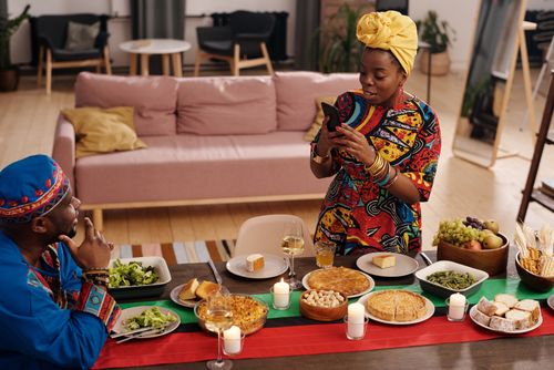 Free A joyful family celebrating Kwanzaa with traditional food and colorful attire indoors. Stock Photo