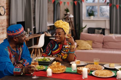 Free African American couple celebrates Kwanzaa with traditional food and joy. Stock Photo