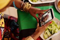 Woman using smartphone for a video call with a festive table setting. Celebrating cultural traditions digitally.
