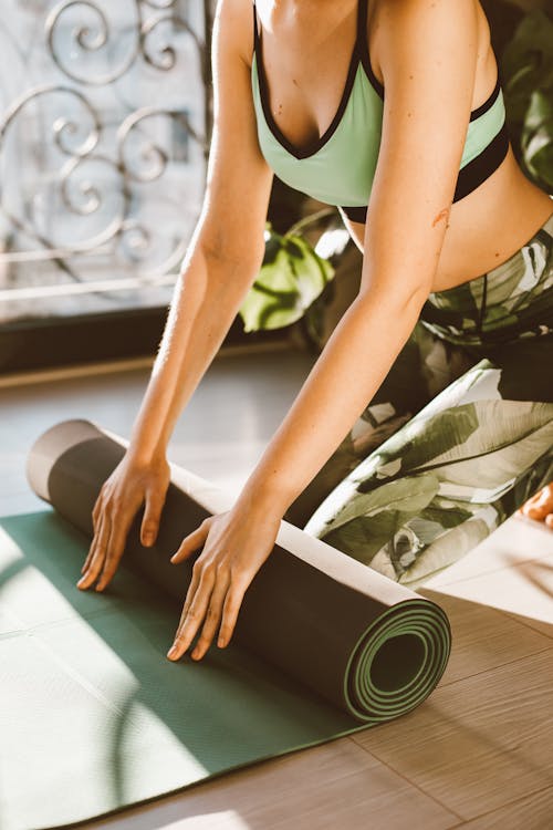 A Person Rolling a Yoga Mat