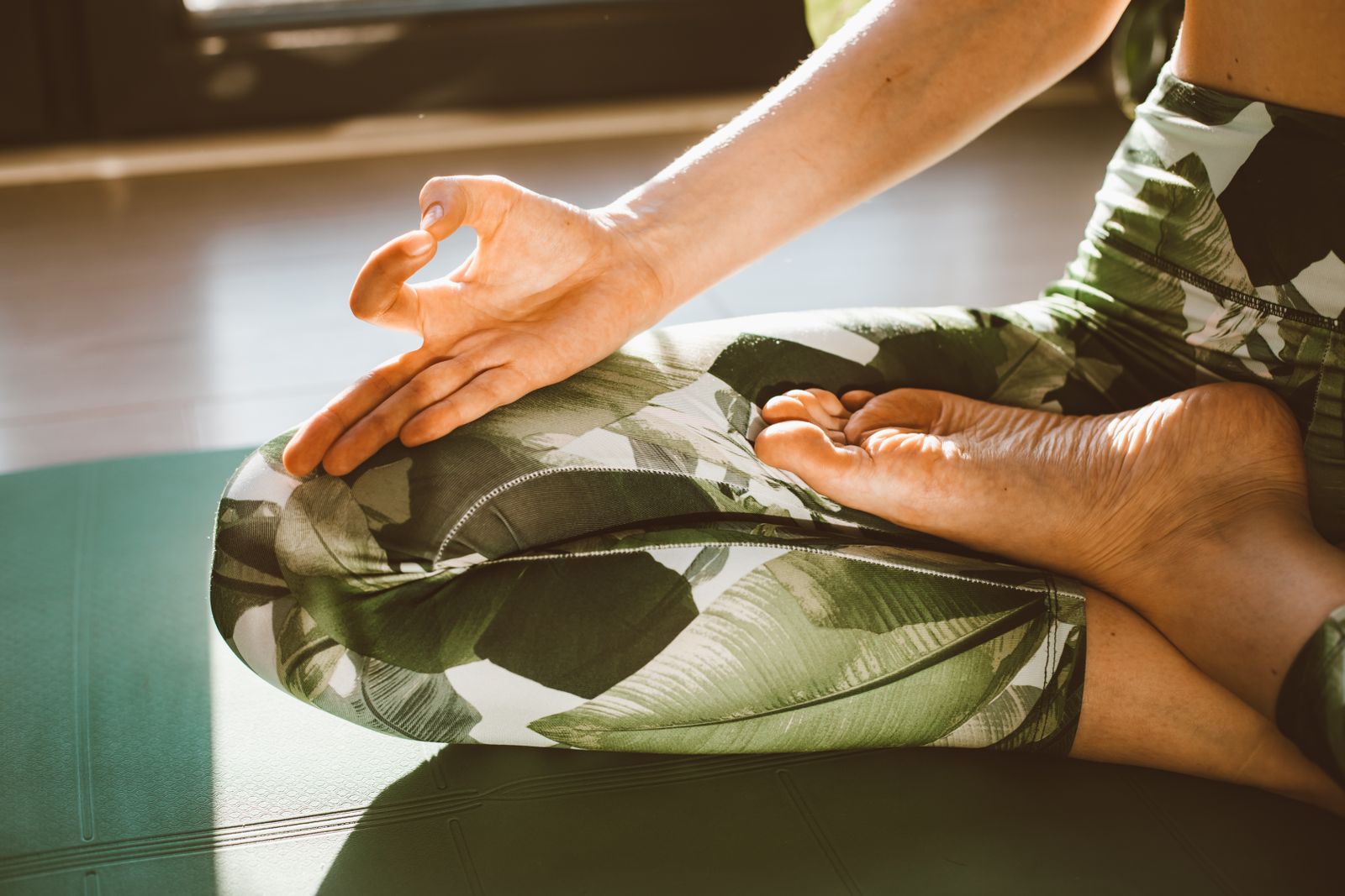 Person seated in a calm meditative lotus position practicing breathing techniques for blood pressure control