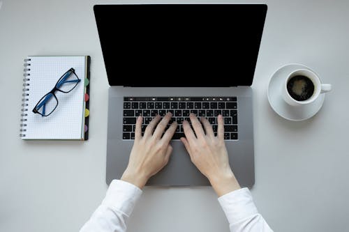 Free A Person Typing on a MacBook Pro Stock Photo