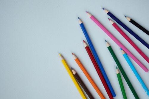 Free Flat lay of vibrant colored pencils arranged diagonally against a soft blue backdrop, ideal for creative themes. Stock Photo