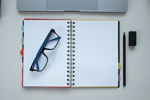 Free Eyeglasses Lying on an Open Notebook  Stock Photo