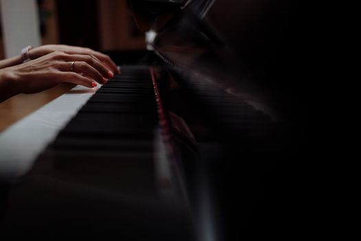 Person Playing Piano in Black Room