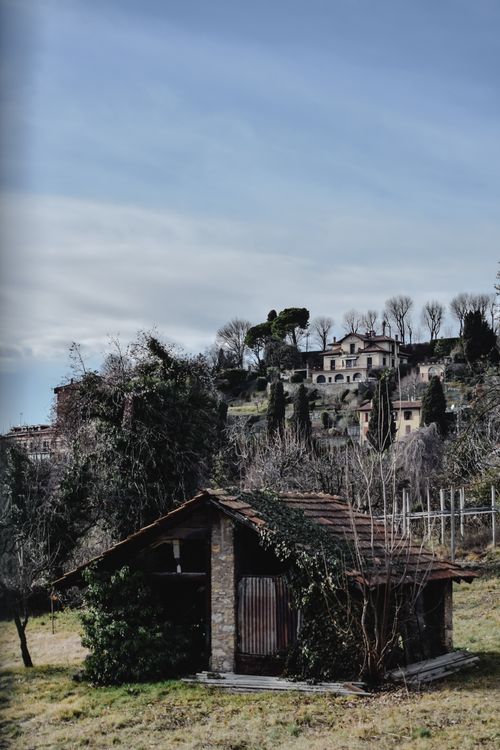 Free Charming rustic landscape in Bergamo, featuring a wooden house amidst lush greenery and trees. Stock Photo