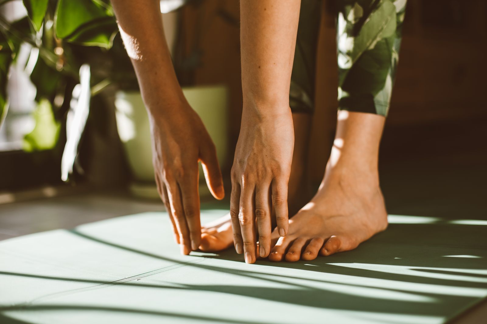 Runner tying shoes on a bright outdoor path before a training run