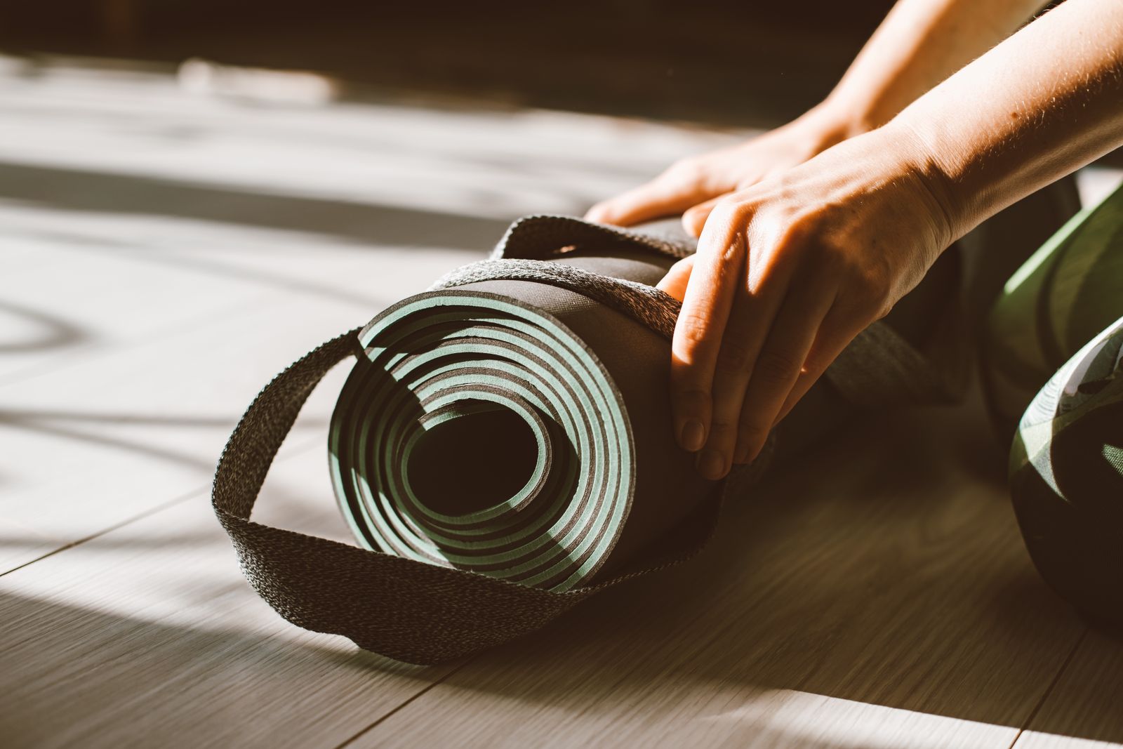 Rolled yoga mat and props set up for a morning practice session
