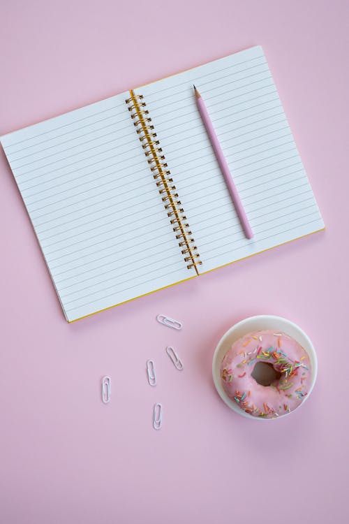 Notebook Beside a Donut