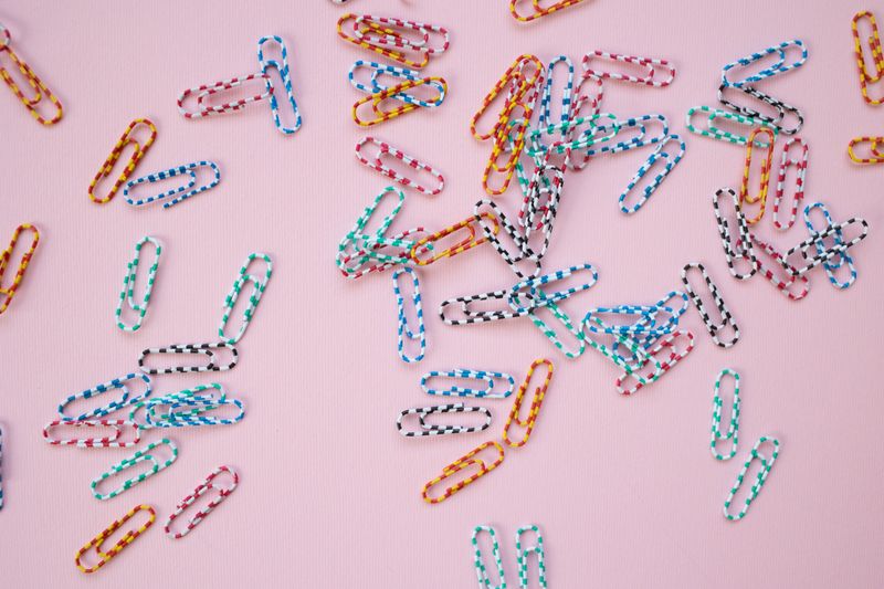 small magnetic tins holding paper clips and pins on a metal surface