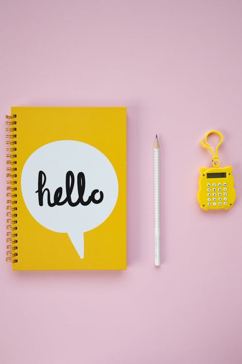 Yellow and White Spring Notebook Beside White Pencil