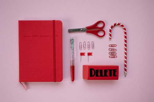 Free A vibrant red stationery set arranged on a light pink surface for creative planning. Stock Photo