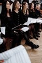 Group of Women in Black Clothing Holding Music Sheets