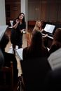 A Woman Standing Next to a Woman Playing Piano