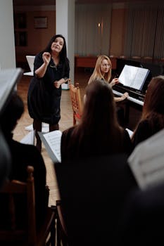 A choir rehearsal indoors with a conductor leading and a pianist accompanying.