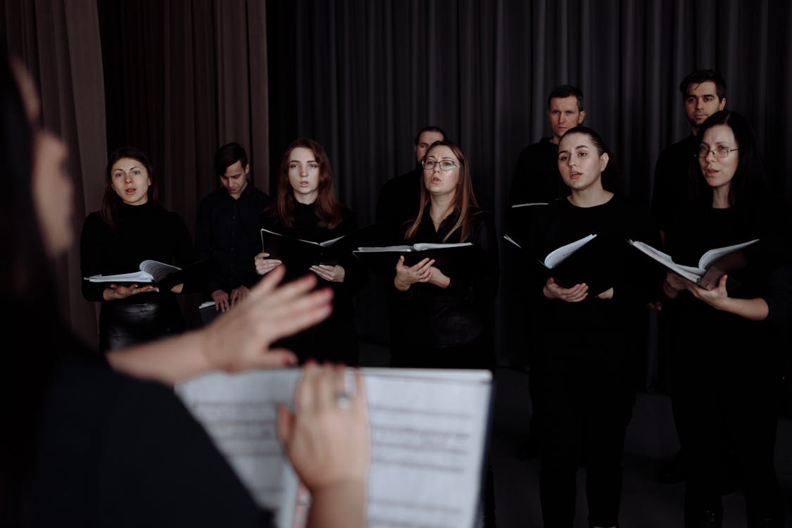 Free A Choir Singing while Holding Music Sheets Stock Photo
