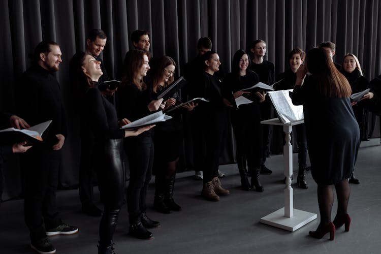 Group Of People Standing In Front Of A Conductor