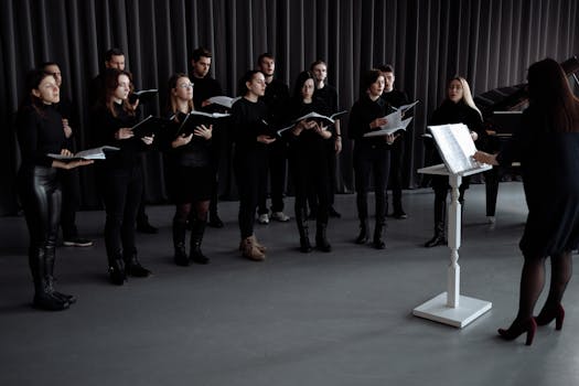 A choir group rehearsing with music sheets under a conductor's direction indoors, focusing on harmony.