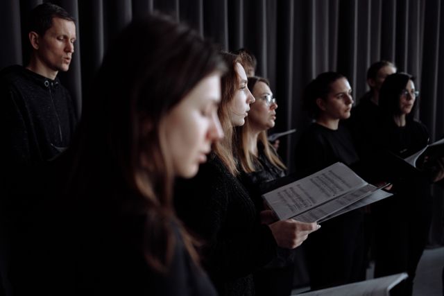 Chœur d'artistes en séance de travail dans un studio, partitions en main